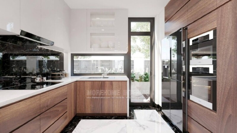 Trong bố trí không gian phòng bếp biệt thự hiện đại, vật liệu ốp bếp rất được chú trọng bởi điều hiển nhiên xảy ra khi nấu nướng sẽ có nhiều vết bắn dầu mỡ nếu không được lau sạch sẽ gây ra ẩm mốc. Khắc phục điều đó, kính ốp bếp hay đá ốp bếp đều là lựa chọn tối ưu, nhưng nếu có điều kiện đá ốp bếp đen chỉ trắng như trong mẫu phòng bếp trong đây sẽ là lựa chọn tuyệt vời. Thiết kế nội thất đá nhân tạo trong không gian nhà